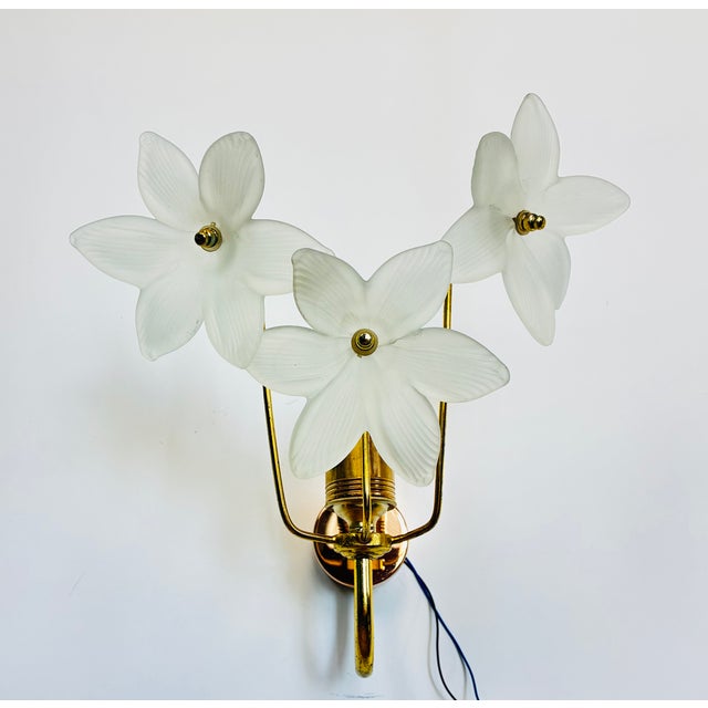 Beautiful vintage wall sconce set from the 1980s. This rare pair features elegant frosted glass flower shades and a warm...