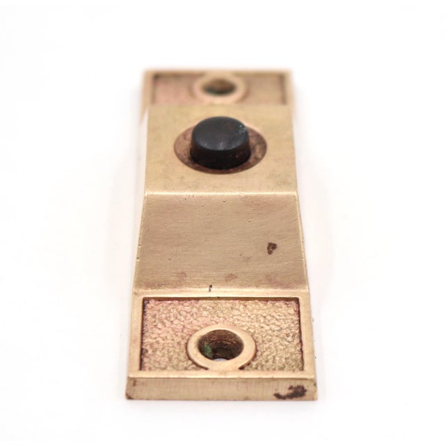 Vintage polished brass door bell plate with a single black plastic button. The original mounting screws are not available....