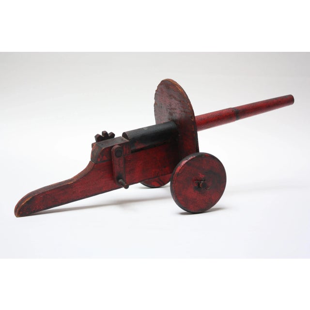 Folk Art toy cannon in original black and red paint, circa 1930s, USA. Very minor paint loss throughout and edge loss to...