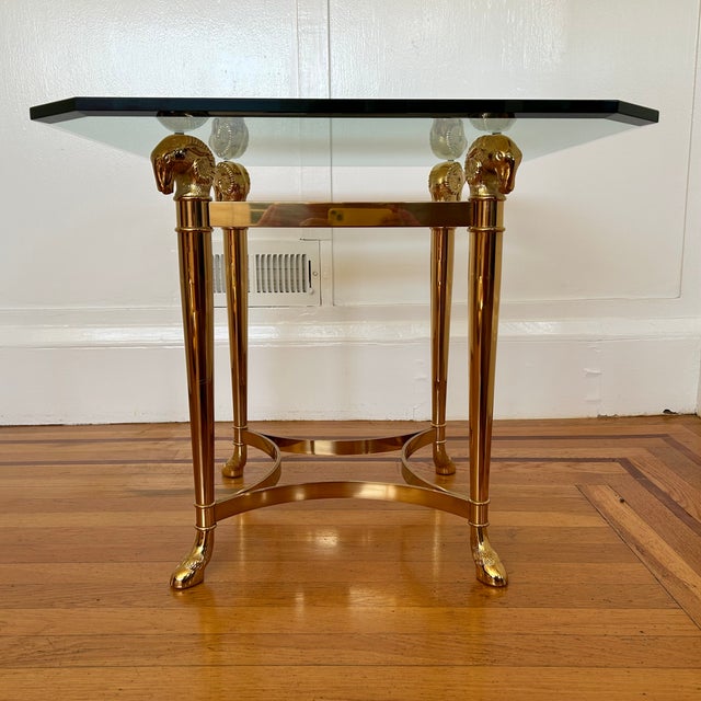 Elegant 80's Hollywood Regency style side table with brass rams head & hoof base and original 1/2" beveled glass top. In...