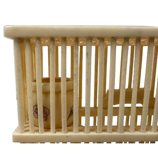 The item in the image is a vintage Chinese cricket cage, meticulously hand-carved from ox bone or cow bone. Historically...