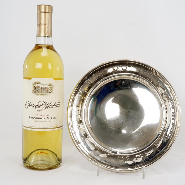 A child's silverplate onder plate or bowl that is shiny, intricate, and funny with a design of little brownies playing...