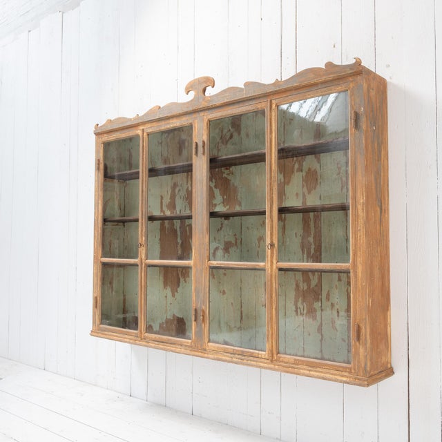 Antique wall-mounted display cabinet dating from the late 19th century, crafted from solid wood and featuring a beautiful...