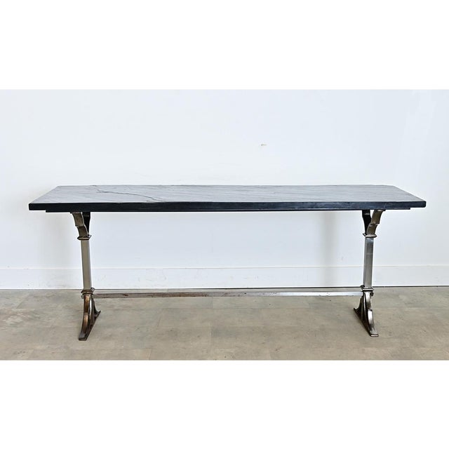 A spectacular iron console table from France, circa 1920, featuring a tactile, dark slate top (1" thick) matching the...