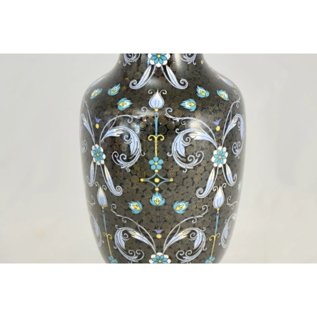 Early 20th Century Chinese ebony noir cloisonné vintage vase hand decorated with a floral design in aqua, blue, yellow and...