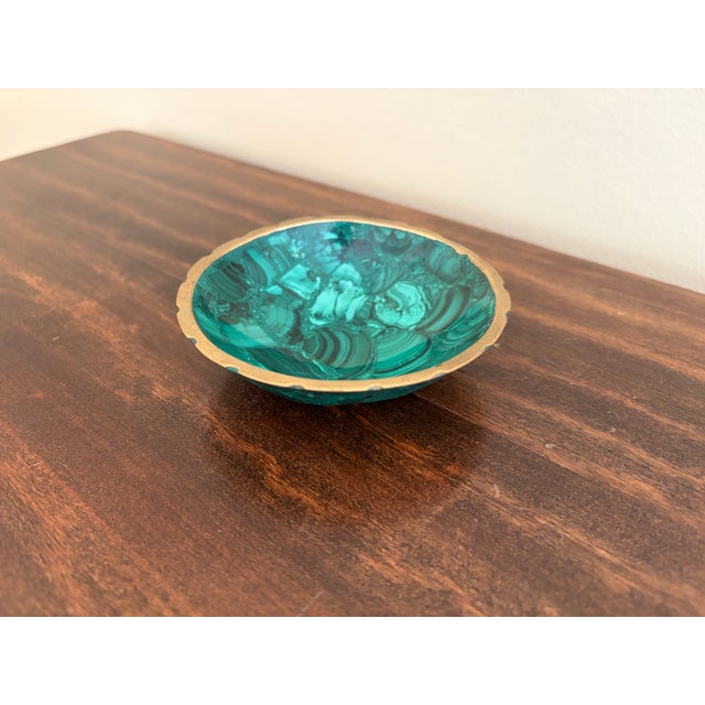 A beautifully proportioned brass rimmed malachite bowl in richly veined shades of green and black. The sculptural...
