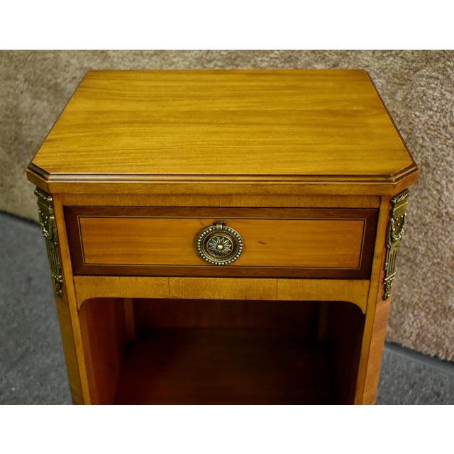 (1940s) Nightstand has a French Style. The Wood is Satinwood. One Drawer. and a Bottom Open Shelf. Brass Ormolu. The...
