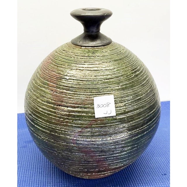 Noted ceramic pottery maker, Andrew Berend spun the texture on this striking ceramic vessel or bud vase in a mutli hue...