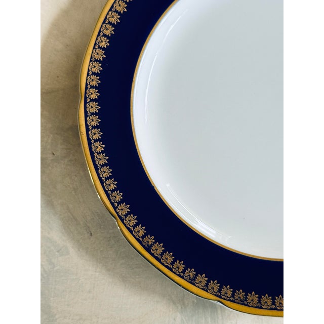 A striking set of seven vintage Noritake Kokura Ware salad or dessert plates, featuring a deep cobalt blue border framed...