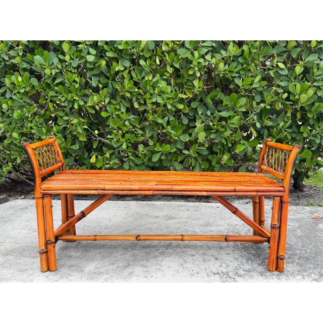 A beautifully crafted vintage split bamboo hall bench featuring woven cane end panels, gently arched supports, and a warm...