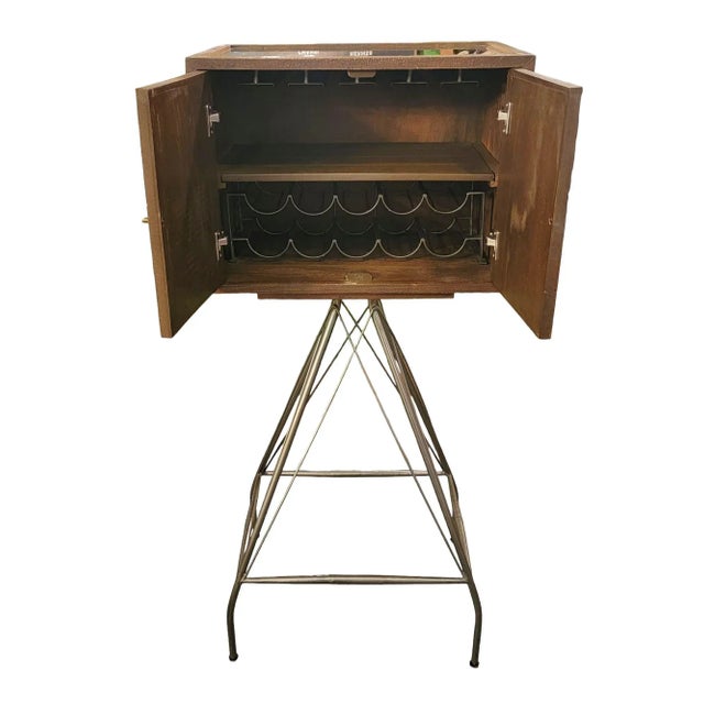 Industrial Bar Cabinet on Metal Stand. There are 4 slits from the top rack to hold cups and 10 slots for wine bottles to...