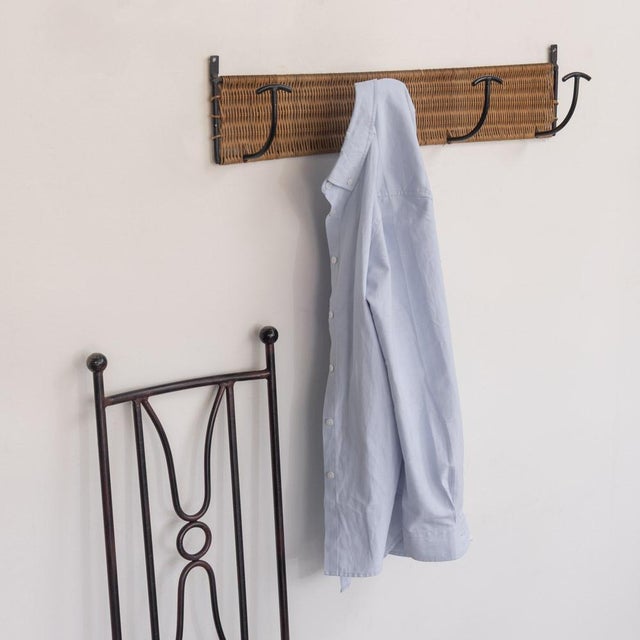 Vintage woven wicker wall rack with 4 iron hooks to hang coats or hats. Black painted iron and wicker is all original....