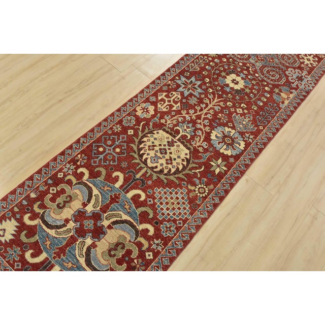 A traditional Suzani runner hand-knotted with fine wool on a cotton foundation. This rug features medallions surrounded by...