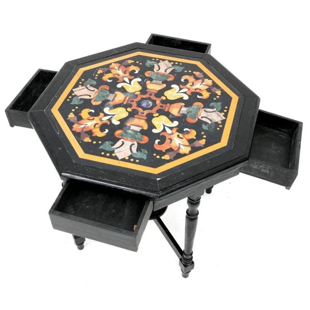 A very fine Italian, 19th century Octagonal Pietra Dura Inlaid Table raised on an ebonized base with four drawers. The...