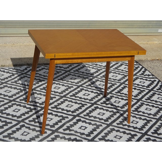 Vintage French-made folding table in oak and light oak veneer, manufactured by SAM in the 1950s. This table is from the...