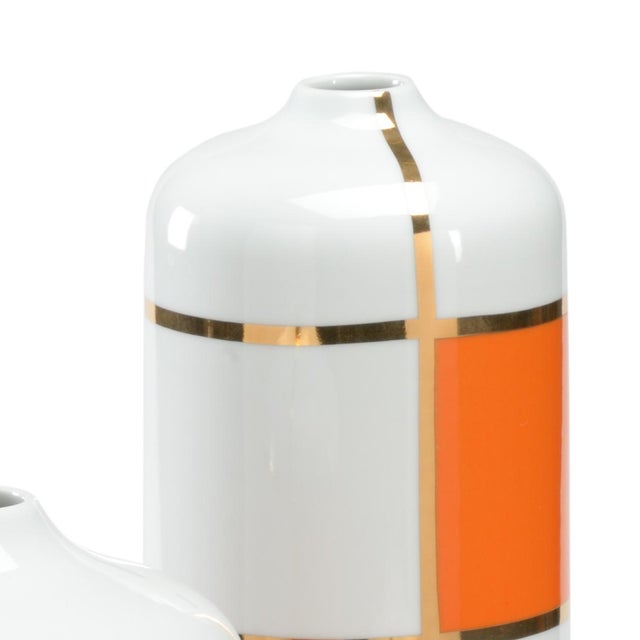set of 3 ceramic canisters with orange block design and gold outline on white glaze. sm-7"h x 7.5"w x 7.5"d, med-11.5"h x...