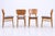 Set of four vintage dining chairs from the 1960s with clean lines and comfortable seating. The warm wood grain and newly...