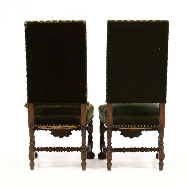 irca 1900, oak, green velvet upholstery with tassel trim and large brass nail head edge, turned and carved stretcher and...