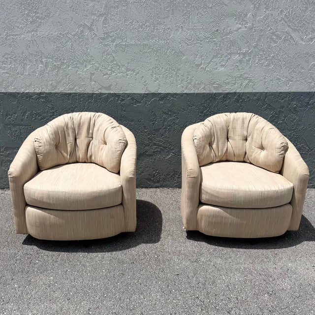 A comfortable pair of postmodern swivel barrel chairs by Best Chairs, featuring a soft, rounded silhouette with inviting...