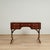 Handsome antique English desk crafted in mahogany with a tooled leather top on a case with five drawers and campaign style...