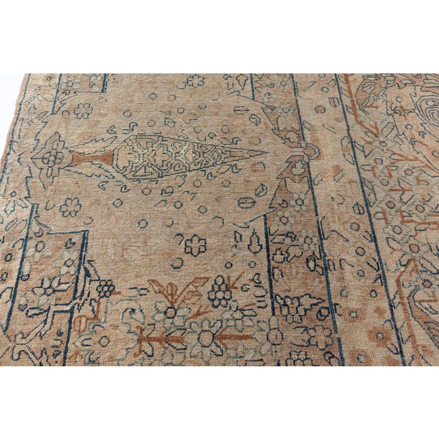A late 19th century Persian Kirman rug, the caramel field with an allover trellis of whimsical enlarged leaves and leafy...