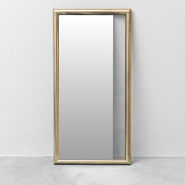1970s wall mirror. Brass frame. Mirrored and clear glass centerpiece. Good condition, shows signs of wear. See photos.