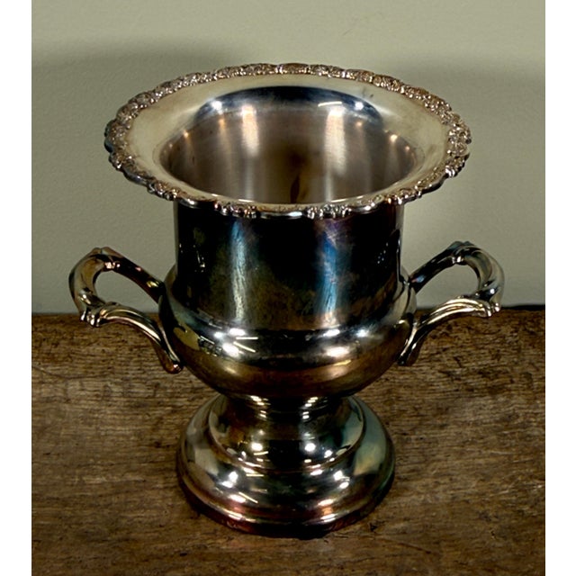 This Oneida silver plated champagne cooler features a classic urn form with a flared decorative rim, twin scroll handles,...