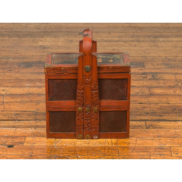 A Chinese vintage tiered rattan and bamboo lunch basket from the mid-20th century, with carved handle and painted lid....