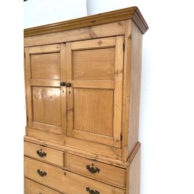 A 19th.century English Pine Linen Cabinet (Linen Press). A 2 part cabinet with a flared cornice top over a paneled top...