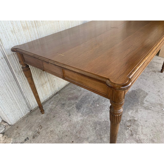 Early 20th large console table with a fold-open top, brass trim detail, and tapered fluted legs . The table has an easy...