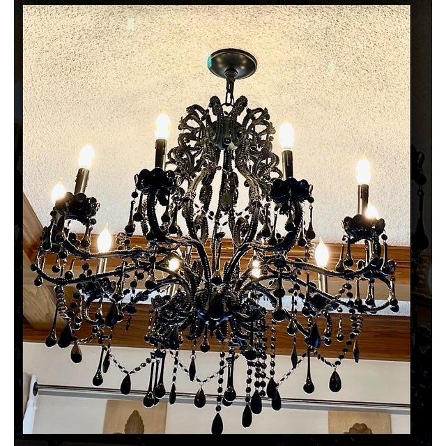 This is an attention grabbing late 20th century black glass chandelier. This large chandelier features 10 candle arms and...