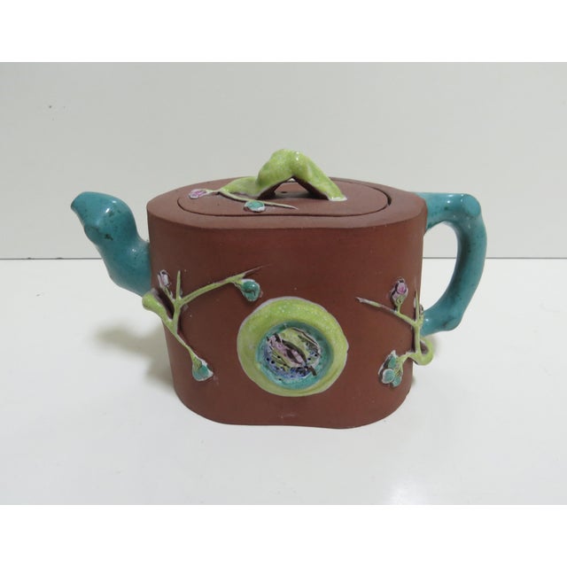 Antique Chinese Yixing Zisha clay teapot, featuring enameled ceramic appliqués prunus flowers and tree branches. Made from...