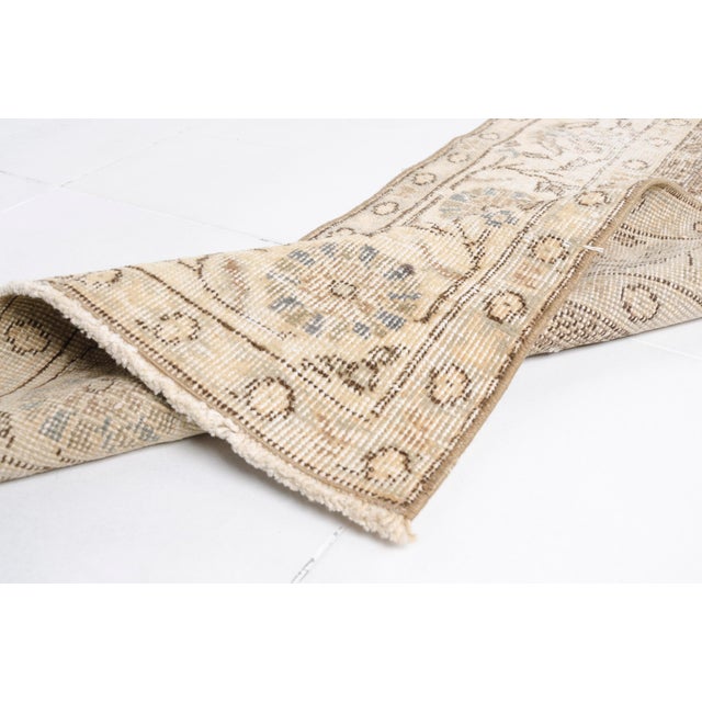 This is a vintage Turkish Oushak rug from the Mid 20th Century. The piece was hand-knotted.