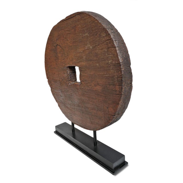 Vintage rustic large wood wheel on black iron stand. Rich warm brown color wood with simple design. Perfect in a modern or...