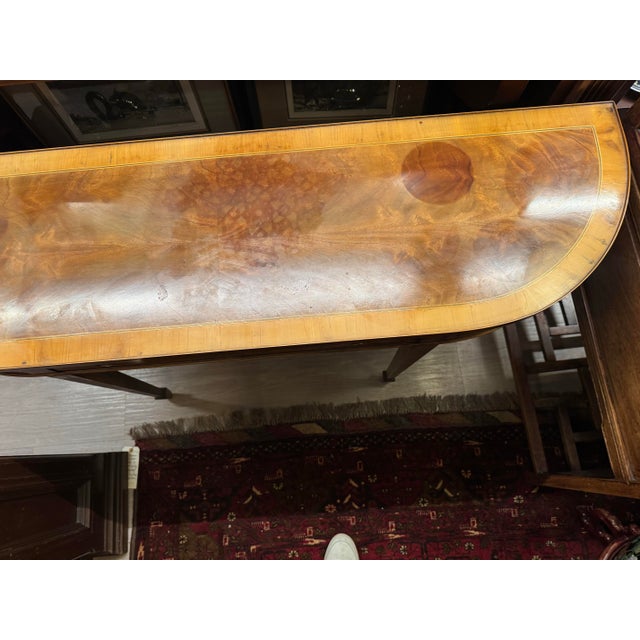 A refined Federal-style crescent sofa table from Hekman’s Copley Collection, featuring elegant proportions and a...