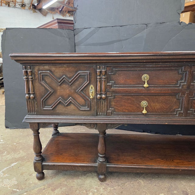 This antique English carved oak sideboard with intricate geometric carvings and brass hardware, would look outstanding in...