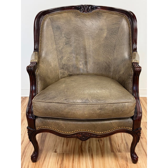 Elegant vintage Hancock & Moore mahogany intricately carved wooden Bergere style chair with rich greige leather...