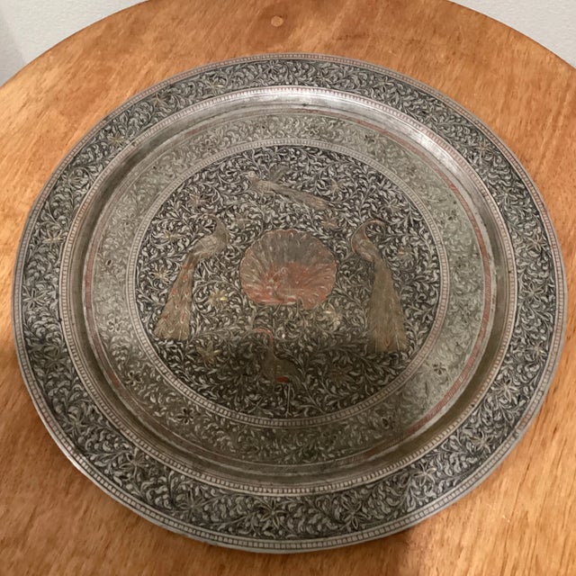 A copper charger with tinned surface covered in etched geometric, floral Persian decorations. A handsome decorative...