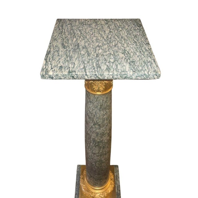 An exceptional 19th century French pedestal featuring a rare and richly veined green marble column accented with finely...