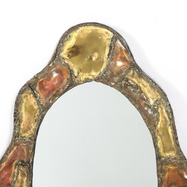 This Mid-Century Brutalist welded brass and copper bordered mirror, crafted in America circa 1974, exemplifies the rugged,...