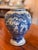 A finely decorated Delft jar featuring intricate hand-painted blue-and-white floral and landscape motifs. The graceful,...