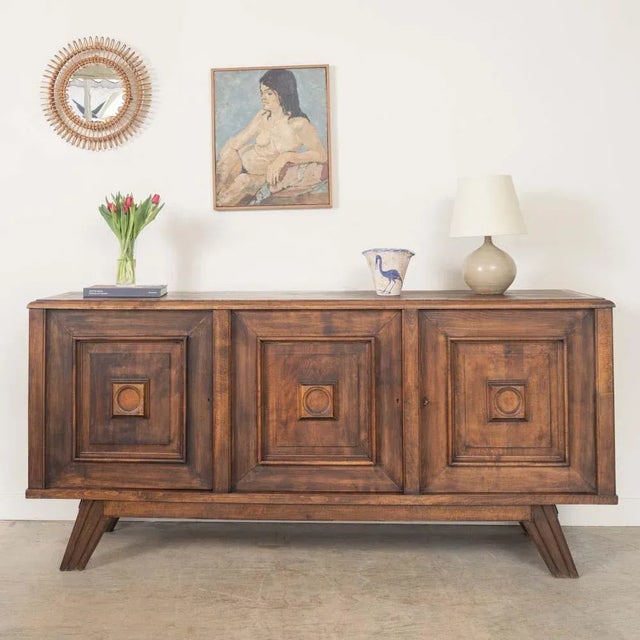 Substantial oak sideboard from France, 1940s. Carved wood square detail on cabinet doors and angular legs. Three doors...
