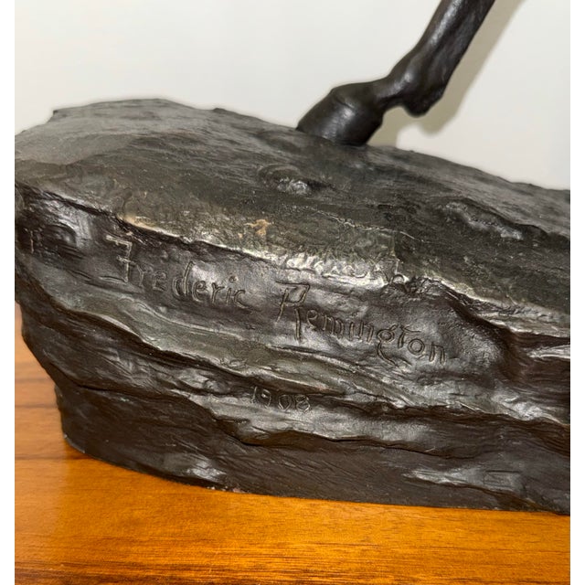 Large and exceptionally heavy cast bronze sculpture depicting a Western rider guiding a horse in motion. The composition...