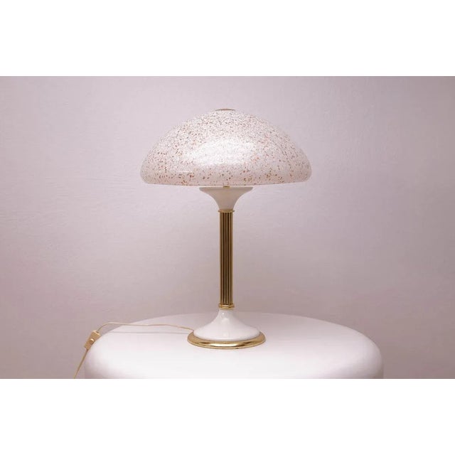 A 1970s table lamp with a classic design. The glass shade is coloured white with numerous coloured speckles. The stem and...