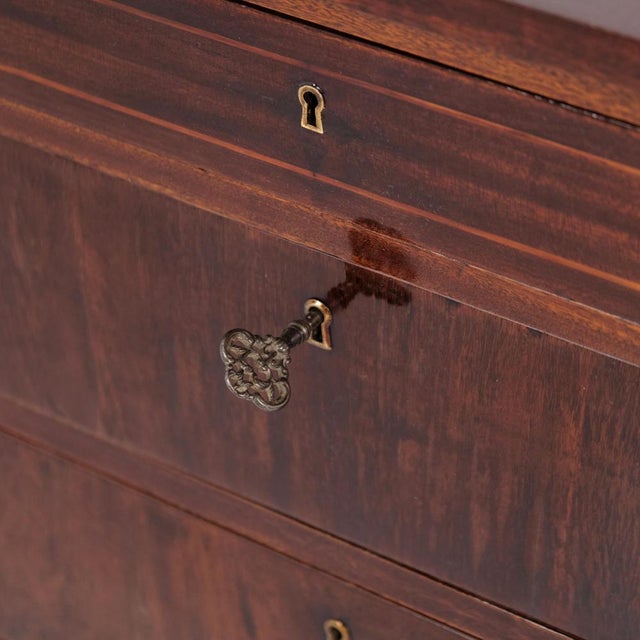 Antique chest of drawers from the 1860s, made of mahogany. The chest features four drawers and stands on tapered legs. A...