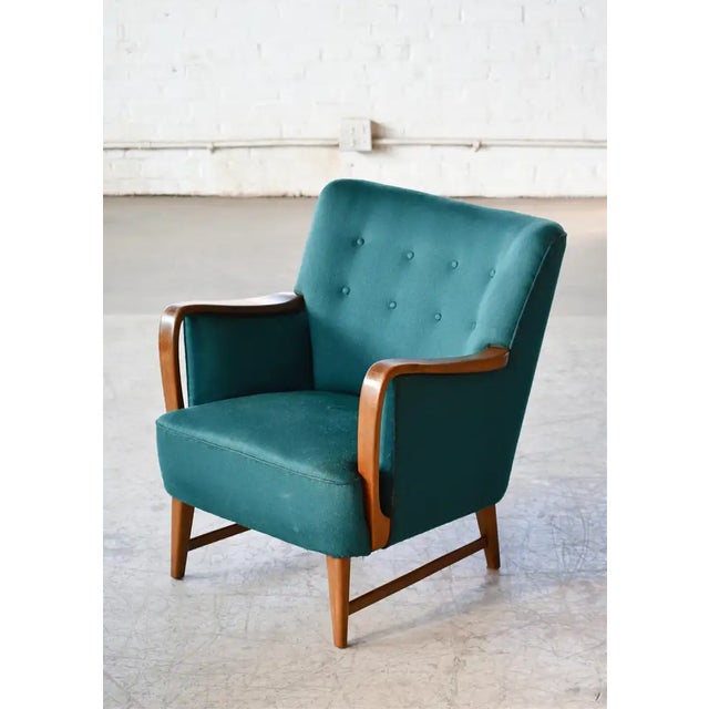 Super charming 1950s lounge chair with armrests and base in a nice golden solid oak. Designed by Kurt Olsen around 1950...