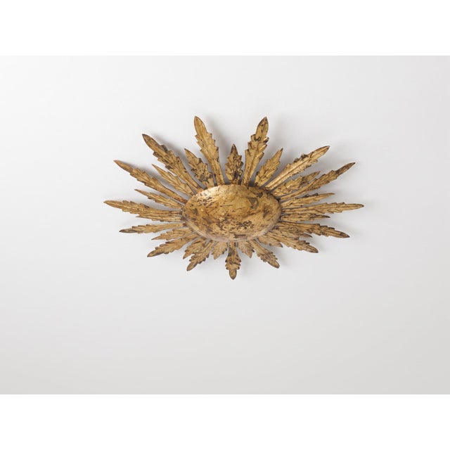 This sunburst ceiling light was made in the 1950s, reflecting the Mid-Century fascination with sun and starburst forms...