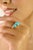 This elegant ring features a 3.32-carat oval cabochon turquoise accented with 0.18 carat round brilliant-cut diamonds. The...