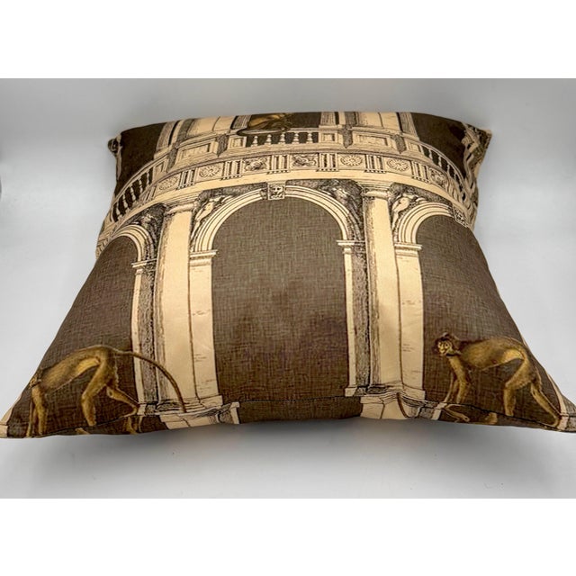 A decorative silk throw pillow featuring an architectural fantasy design in the style of Fornasetti, with classical...