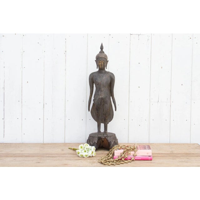Our exquisite 19th century carved wood Burmese standing Buddha stands gracefully atop a lotus pedestal flower, symbolizing...